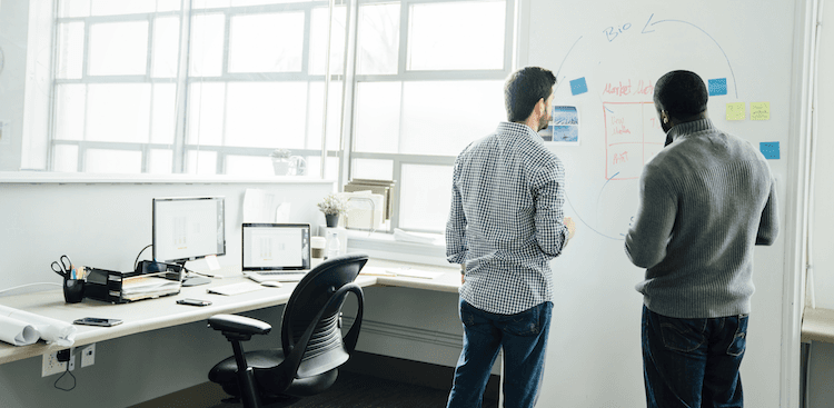 two people standing in an office